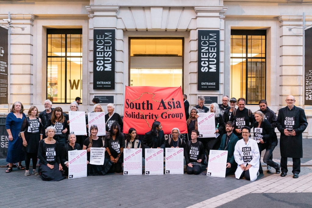 Protests with boycott placards and a South Asia Solidarity Group banner in front of the Science Museum entrance